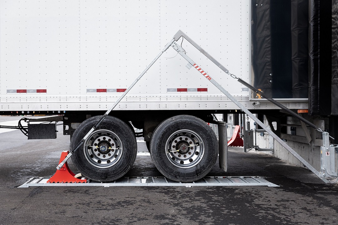 Wheel chock POWERCHOCK 5 set up in front of truck wheel on ground plate