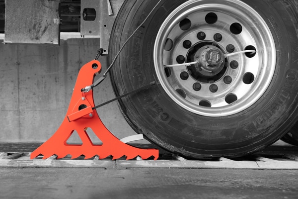 POWER CHOCK® 3 wheel-based vehicle restraint system that is effectively restraining the wheel of the truck on the ground-anchored restraining plate