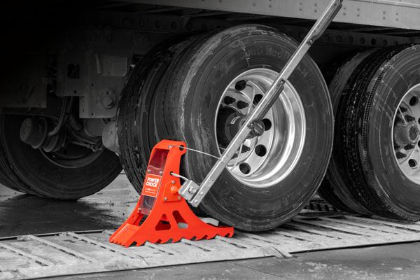 Le POWER CHOCK® 5 qui retient la roue arrière du camion en le sécurisant au quai de chargement